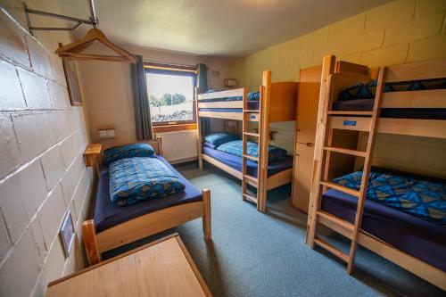a room with three bunk beds and a window at Torridon Youth Hostel in Torridon