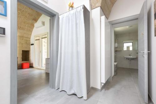 a white shower curtain in a bathroom with a sink at Villa Queen by Perle di Puglia in Lecce