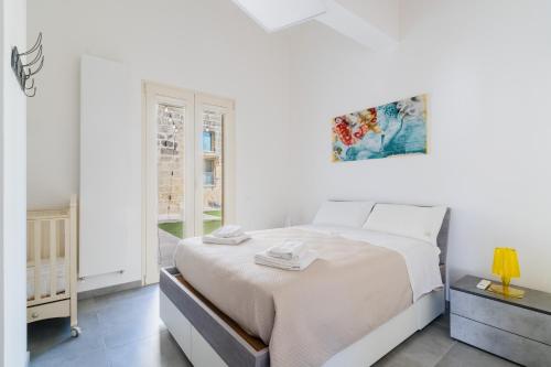 a white bedroom with a bed and a window at Villa Queen by Perle di Puglia in Lecce