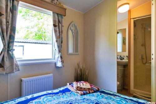 a bedroom with a bed and a window and a sink at Finest Retreats - Seascape in Porchfield