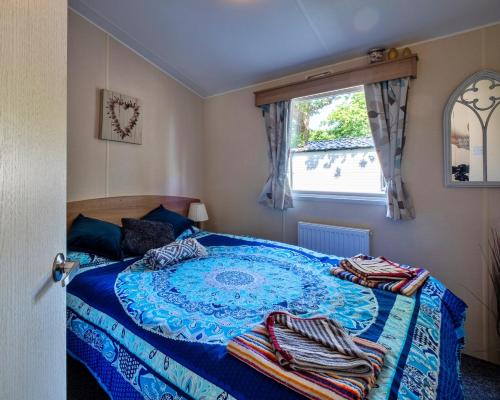 a bedroom with a blue bed with towels on it at Finest Retreats - Seascape in Porchfield