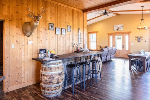 a bar with a deer head hanging on a wall at Tall Tine Lodge in La Prairie