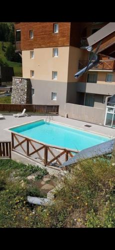 a large swimming pool in front of a building at T2 view, skiing, summer pool Balcons du Soleil in Allos