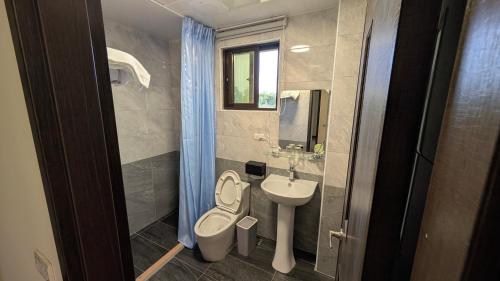 a bathroom with a toilet and a sink at Ronglai Inn in Jinning