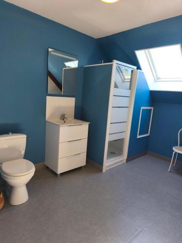a bathroom with a toilet and a blue wall at Gîte Mouchel in Le Vrétot
