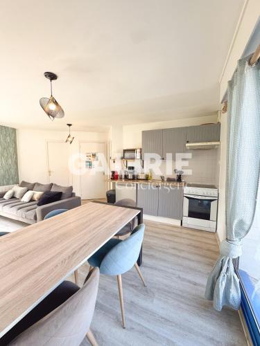 a kitchen and living room with a wooden table and chairs at GC - Entre Terre Et Mer in Wissant