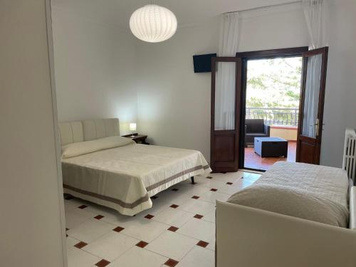 a bedroom with two beds and a sliding glass door at Villa Bice in Pulsano