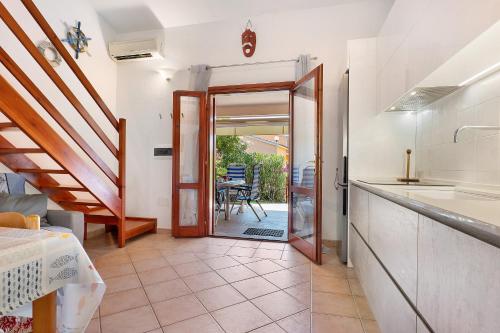 a kitchen with a door leading to a patio at Bilo Lu Impostu in Nuragheddu