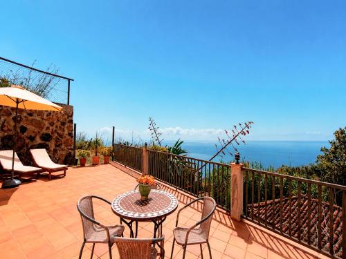 a patio with a table and chairs and the ocean at Neólida in Puntallana