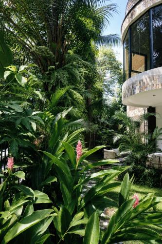 a garden with pink flowers and plants next to a building at Luxor Gardens Residences in Accra