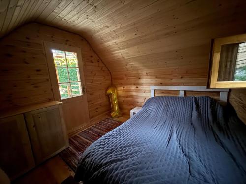 a bedroom with a bed in a wooden cabin at Cabanele din RÂTUL FLORILOR in Hotar