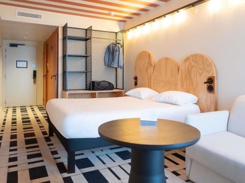 a room with two beds and a table and a couch at ibis Styles Montauban in Montauban