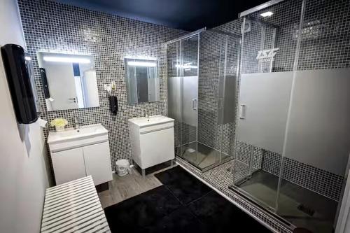 a bathroom with two sinks and a shower and a toilet at CyberHostel Almada in Almada