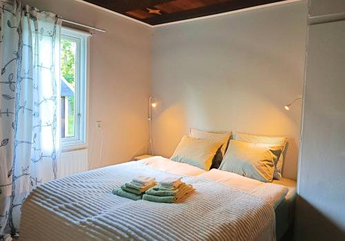 a bedroom with a bed with towels on it at Solkullen i Kalvshult in Hallaryd