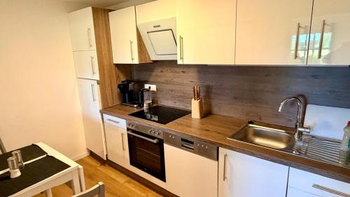 a kitchen with white cabinets and a sink at Longinus Quartier in Havixbeck