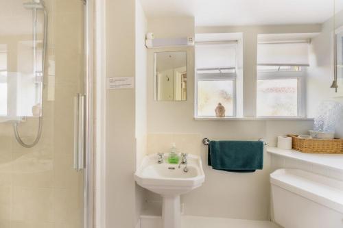 a white bathroom with a sink and a shower at 2 Bed in Beaminster oc-63136 in Stoke Abbott