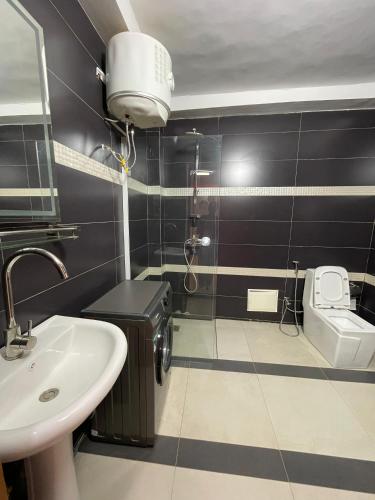 a bathroom with a sink and a toilet at Résidence You Royal in Dakar