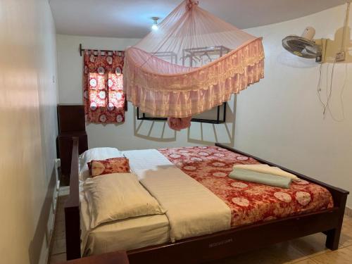 a bedroom with a bed with a mosquito net at Palm Garden Guest House in Gulu