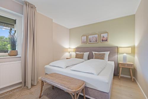a bedroom with a large white bed and a window at Nordseebude Kleine Auszeit in Sankt Peter-Ording