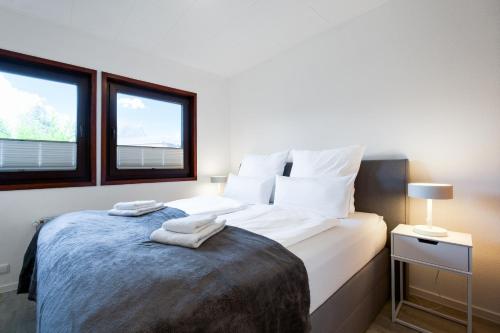 a bedroom with a bed with two towels on it at Küsten Auszeit in Guttau