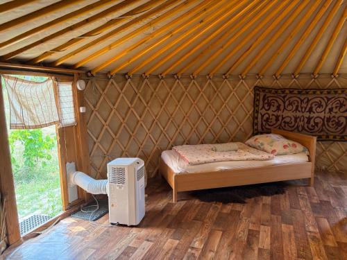 a room with a bed and a television in a yurt at Erdősmecskei sváb vendégházak és Jurtaszállás in Erdősmecske