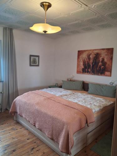 a bedroom with a bed with a painting on the wall at Ferienwohnung Friedel und Käthe in Oberthal