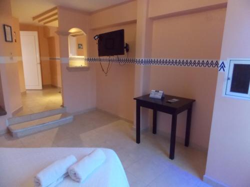 a room with a bed and a table and a television at Hotel Express Alejandría in Xalapa
