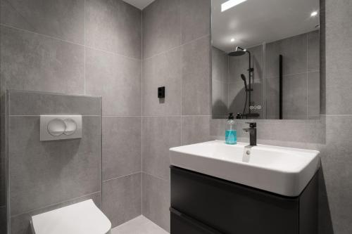 a bathroom with a sink and a toilet and a mirror at View Studios in Åre