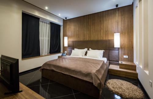a bedroom with a large bed and a television at Hotel Crystal Light in Niš