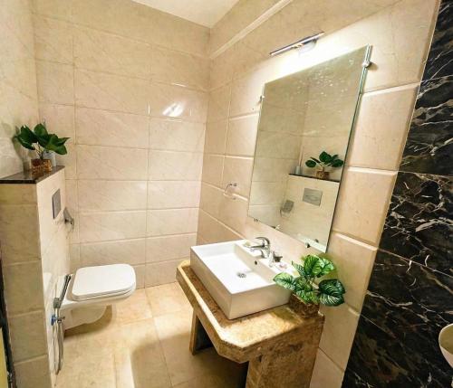 a bathroom with a sink and a toilet and a mirror at Rovio in Vagator