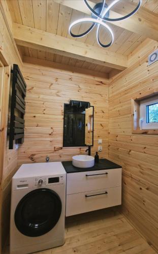 a bathroom with a washing machine in a wooden room at Sarenka na Roztoczu in Nielisz