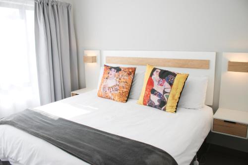 a bedroom with a white bed with pillows at White Orchid Luxury Apartment in Chartwell