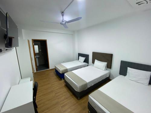 a small room with two beds and a tv at GRAND HOTEL ViLLA ROSA in Tingo María