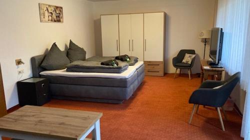a room with a bed and a couch and a chair at Gasthof Walhalja in Schmallenberg