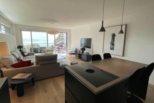 a living room with a couch and a table at Les Terrasses de Lavaux-2 Appartement de Luxe avec Vue Panoramique et Piscine" in Chexbres