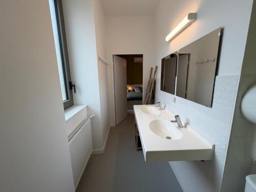 a white bathroom with two sinks and a mirror at Les Terrasses du Rhône, Baix in Baix