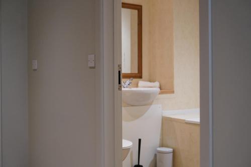 a bathroom with a toilet and a sink at Meadows Hotel in Perranzabuloe