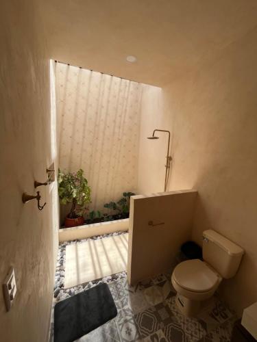 a small bathroom with a toilet and a window at Casa Sayab Hotel Boutique in Maní