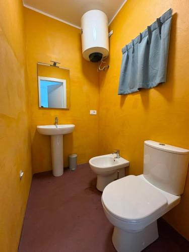 a yellow bathroom with a toilet and a sink at ARTEAMARE in Vignanotica in Mattinata