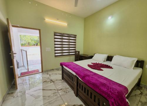 a bedroom with a large bed with a red flower on it at Beach Way Villa in Varkala