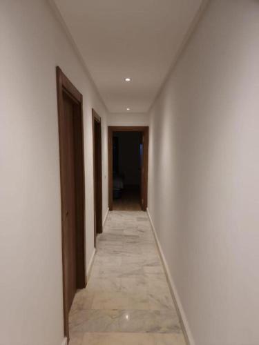 a hallway with white walls and a tile floor at Blue water house in Dar Bouazza