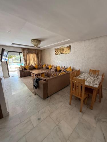 a living room with a couch and a table at Blue water house in Dar Bouazza