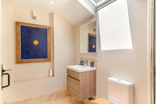 a bathroom with a sink and a toilet and a painting at 2 Bed in Bridport oc-dc110 in Chideock