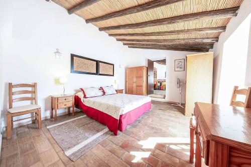 a bedroom with a bed and a wooden ceiling at Casa Nomanico in Estói