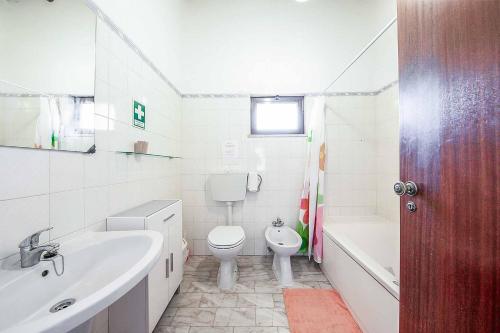 a bathroom with a sink and a toilet and a bath tub at Casa Nomanico in Estói
