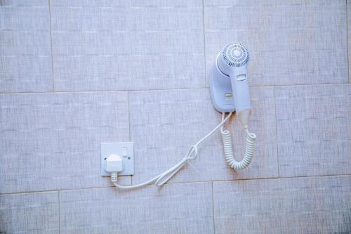 a blue phone on a wall in a bathroom at ExtraMile Apartments - 2BR in Dodoma