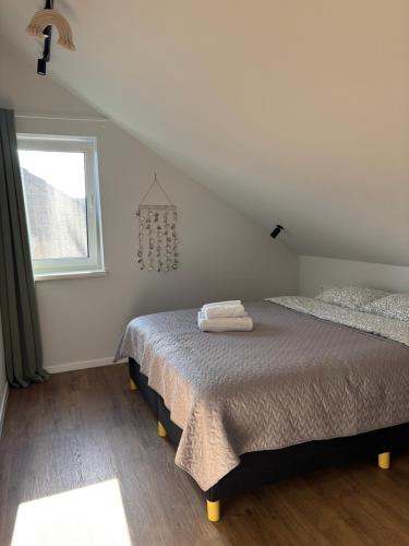 a white bedroom with a bed and a window at Tavo Jūros Namai in Palanga