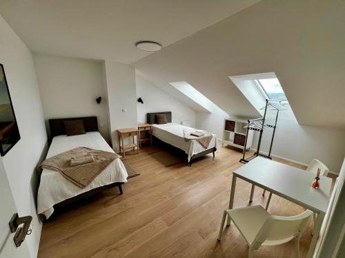 a bedroom with two beds and a desk and a table at Luxury Gerlach Mountain Mezonet I in Svätý Jur