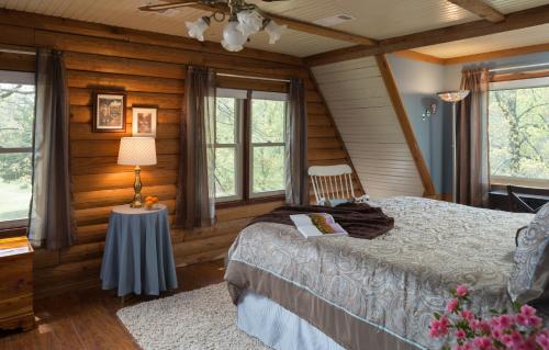 a bedroom with a bed and a table and windows at Tiffany's Bed and Breakfast in Bismarck