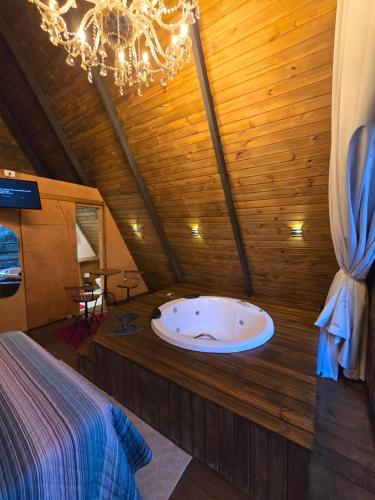 a bathroom with a tub in the middle of a room at Chalé Cristal Capivari in Campos do Jordão